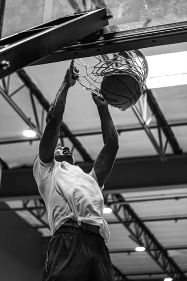 Finishing a two-handed dunk at the rim.